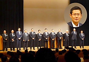 JII参加卸(左から8人目まで)を代表してあいさつした国分の國分晃専務(右上=円内)は、商品画像では卸の個別要請でメーカーの営業担当者に苦労をかけているとし、今回の画像情報流通の効率化への理解を求めた