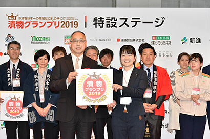 東野昭浩課長(中央左)からグランプリのロゴマークを授与された田口あゆみ係長(同右)
