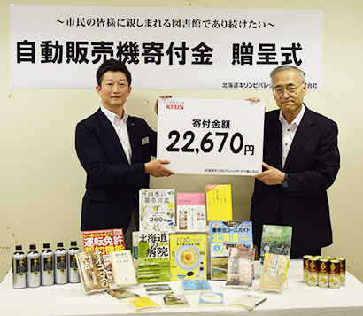 土田雄一北海道キリンビバレッジサービス札幌支店長（左）と鈴木浩一市立小樽図書館館長