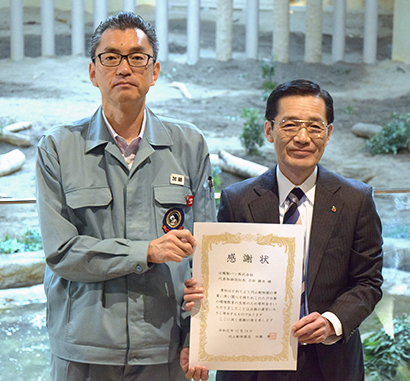 寄付金の目録を手渡し、動物園から感謝状が贈られた。加藤修園長（左）と信田紀生常務