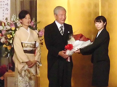 花束を受け取る川崎尚一氏と和子夫人（左）