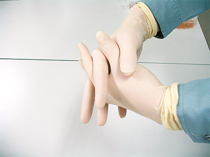Photo10　両手の手袋を着用してから手首部分のみを引っ張る　指先のゆとりを調整する