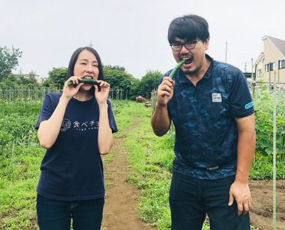 生産者と取れたてのキュウリを食べる秋元里奈社長（左）