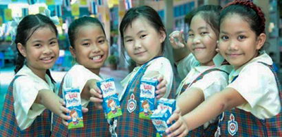 学校牛乳「ノム・リーアン」を手にする子どもたち＝タイ酪農振興財団提供