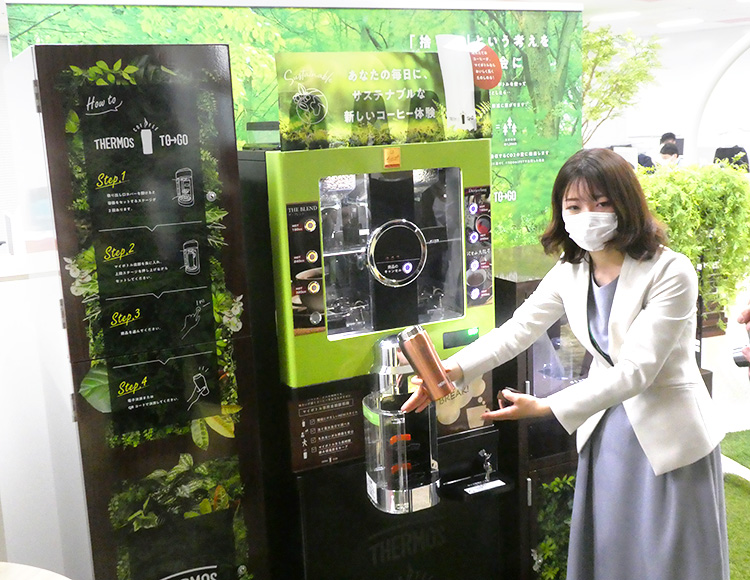 実証実験に使用するコーヒーマシンの説明をする東京建物の阿部里紗子主任