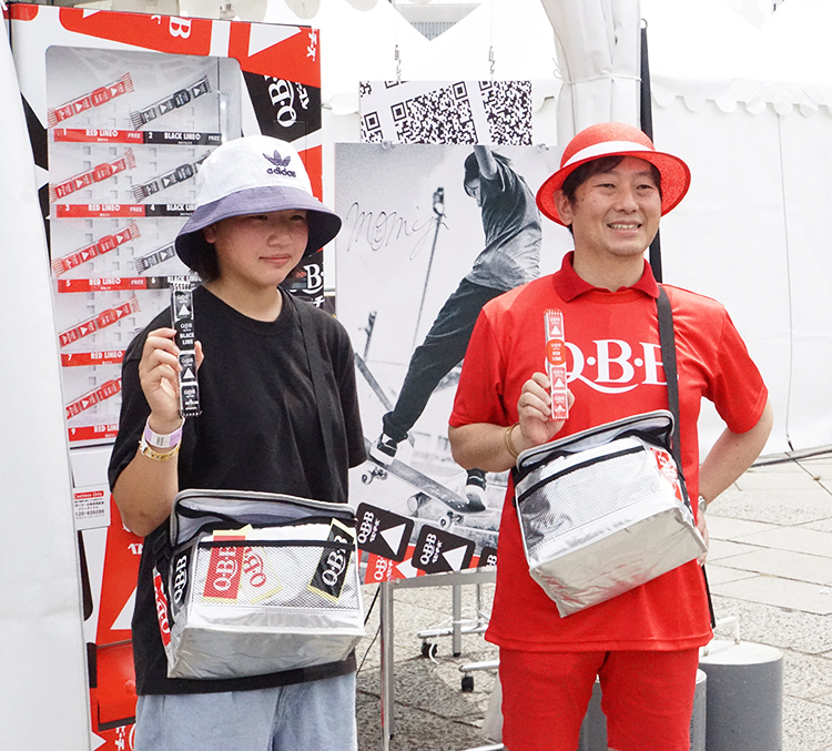金メダリストの西矢椛選手（左）が塚本浩康社長と限定パッケージをサンプリング。