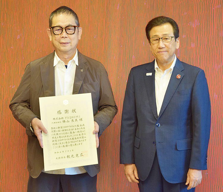 感謝状を手にするYOSHIMIの勝山良美代表取締役社長兼オーナーシェフ（左）と秋元克広札幌市長