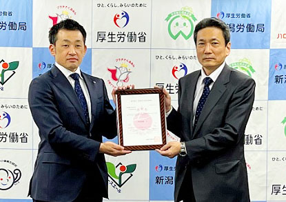 金子浩之亀田製菓総務部長（左）と西岡邦昭新潟労働局長