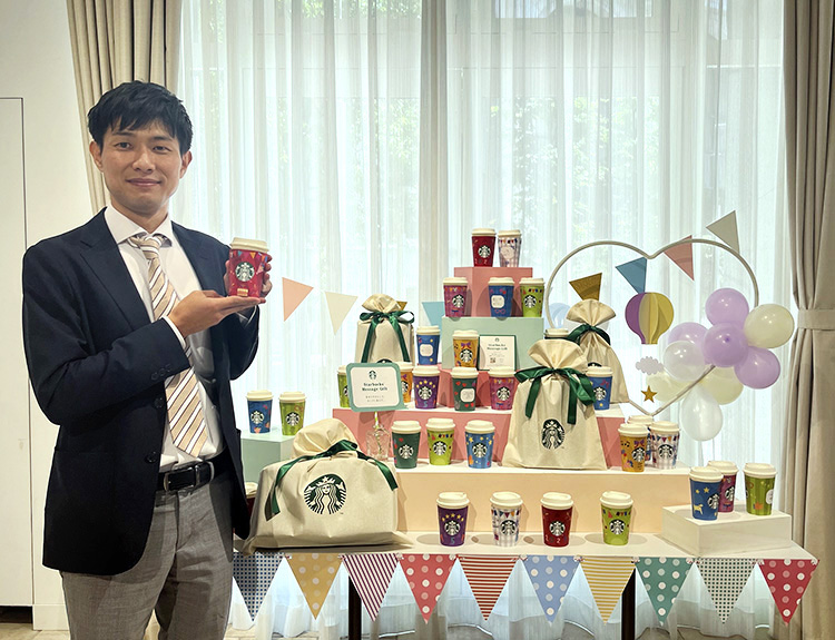 「スターバックスのカップ」を手にするスターバックスCPG部の田渕敬章氏
