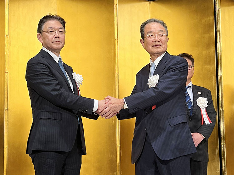 JSAの通常総会後のパーティーで握手する岩崎高治新会長（左）と川野幸夫名誉会長（6月30日）