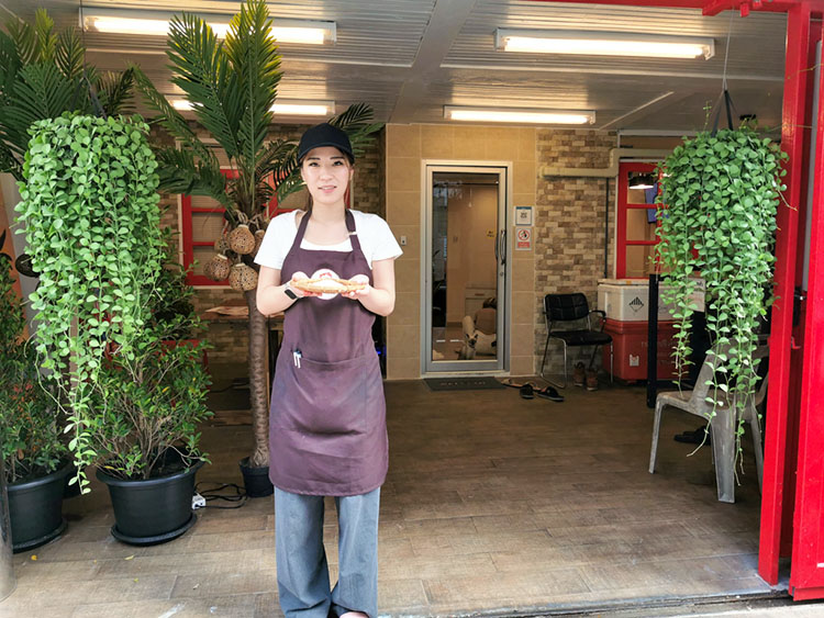 バンコクに誕生したおにぎり専門店「こめこめCLUB」と調理担当のリサさん＝タイ・バンコクで小堀晋一が11月8日写す