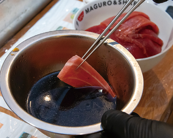 マグロの切り身は煮切り醤油をくぐらせてから酢飯にのせる