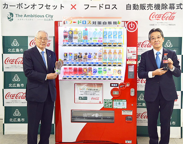 除幕された自動販売機と上野正三市長（左）と酒寄正太社長