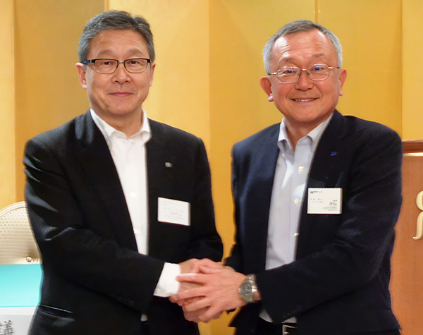 握手を交わす竹内昭二前理事長（右）と岡田浩幸新理事長