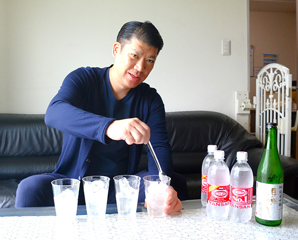 氷を入れたグラスに日本酒を注ぎ、炭酸水と1対1で割る「日本酒のソーダ割り」を提案する佐々木健太専務