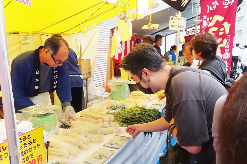 大勢の人たちがべったら市を訪れ、複数の屋台の試食で味を比べながらべったら漬けを買い求めた