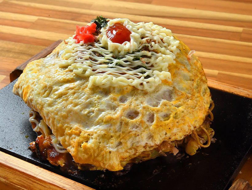 ワケありの盛り付け：他店と差別化できる看板商品　お好み焼きにオムそばをオン！
